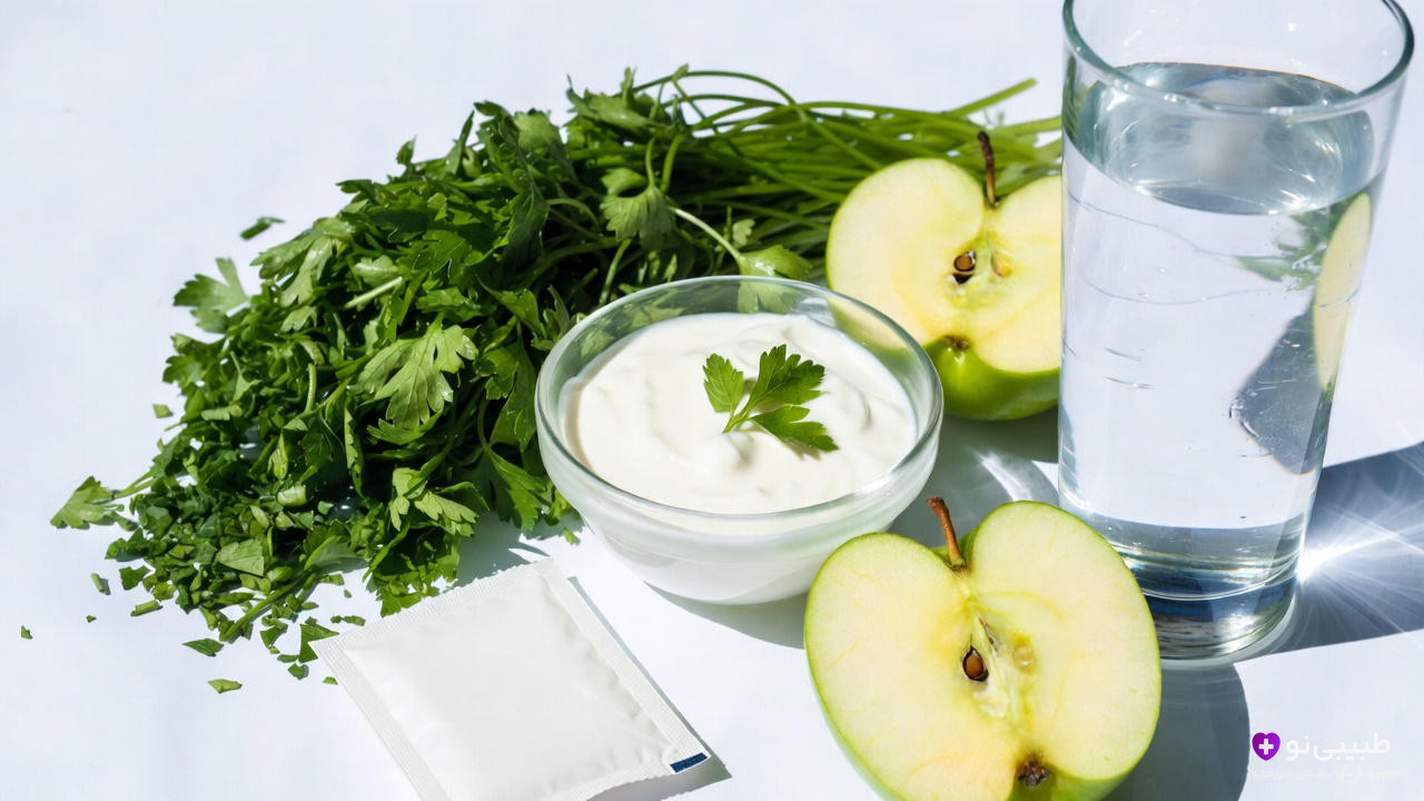 مجموعه&zwnj;ای از مواد طبیعی برای رفع بوی بد دهان: جعفری تازه خردشده، کاسه ماست ساده با برگ جعفری روی آن، برش&zwnj;های سیب سبز، لیوان آب و یک بسته پودر جوش شیرین روی زمینه سفید