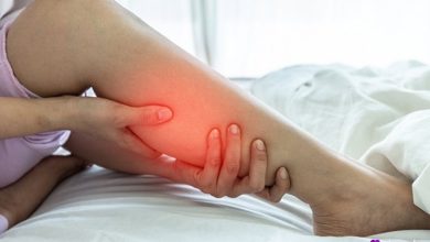 زنی که روی تخت دراز کشیده و پای دردناک خودش رو با دست نگه داشته، با ناحیه قرمز رنگ برای نشان دادن درد