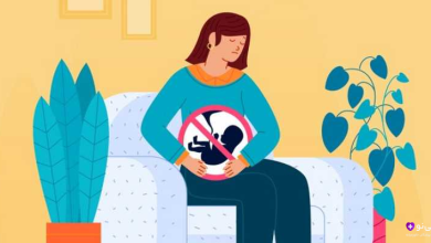 زنی باردار که روی کاناپه نشسته و نماد "بدون جنین" روی شکم او قرار دارد، در حالی که گیاهان خانگی اطرافش هستند، نمادی از لحظه‌ای احساسی یا تأمل‌برانگیز مرتبط با بارداری.