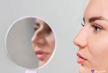 نمای نیم‌رخ خانم جوان با پوست صاف و بینی طبیعی؛ نشان دادن بینی قبل از پرزرویشن رینوپلاستی در آینه