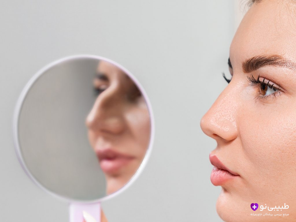 نمای نیم‌رخ خانم جوان با پوست صاف و بینی طبیعی؛ نشان دادن بینی قبل از پرزرویشن رینوپلاستی در آینه