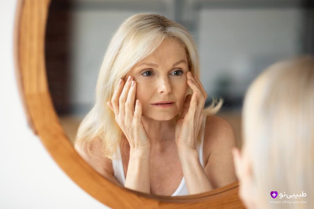 بررسی پوست صورت توسط خانم میانسال؛ نمایش افتادگی پوست ناشی از کاهش حجم